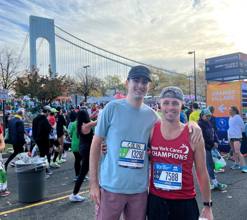 runners standing in front of the brooklyn bridge