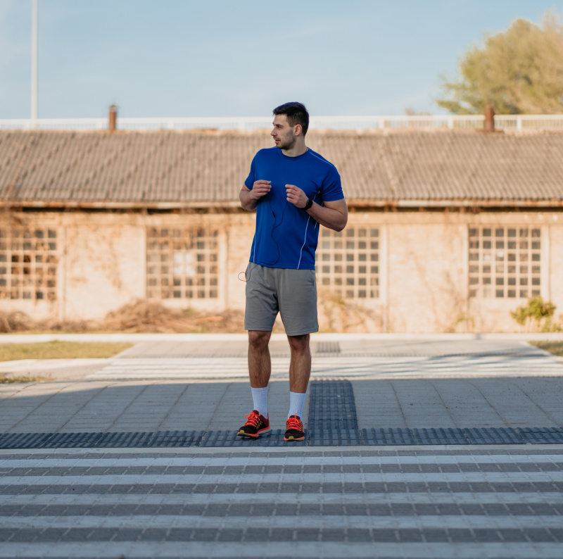 runner waiting to cross safely at crosswalk