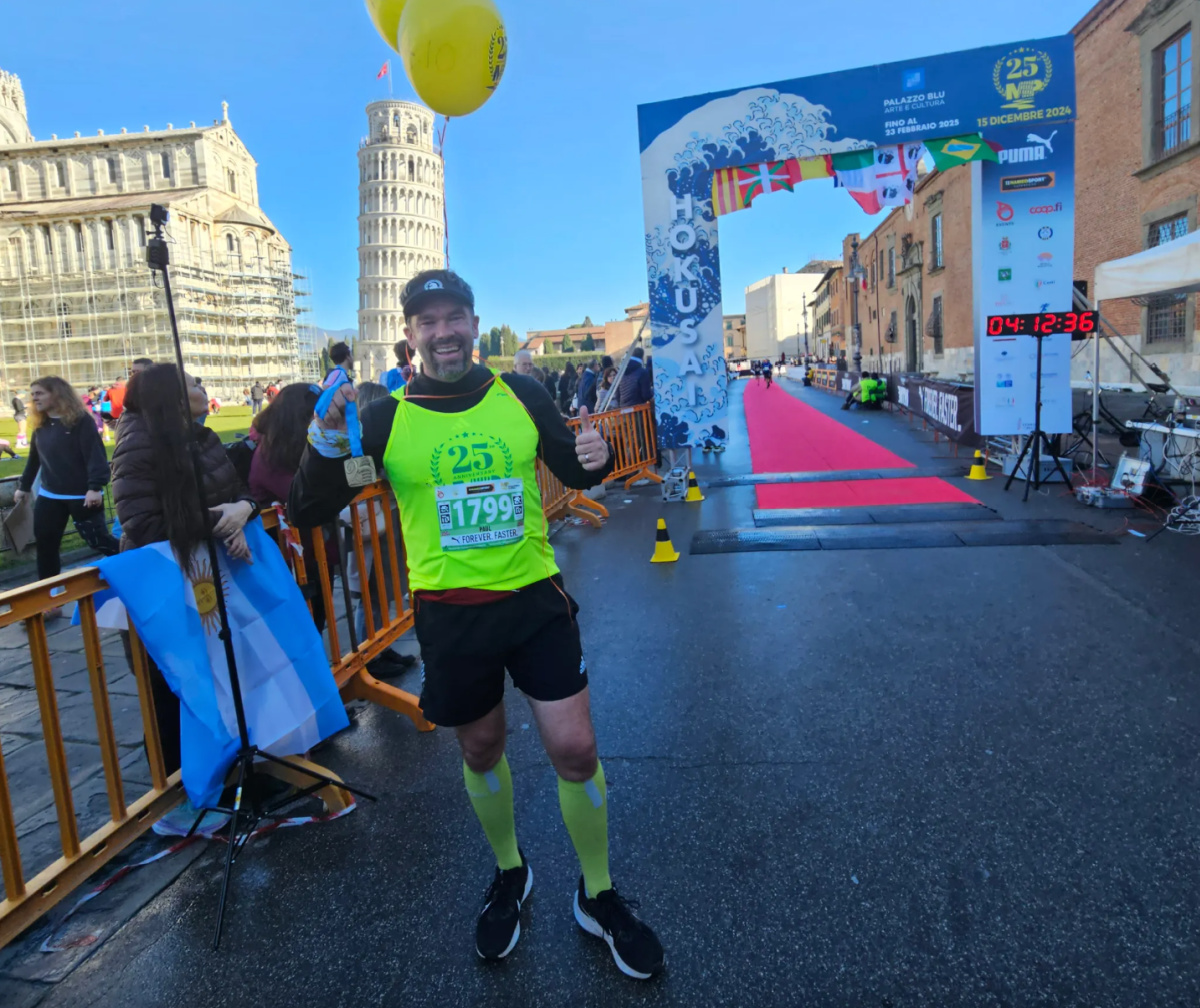 man at the finish line at the Pisa Marathon
