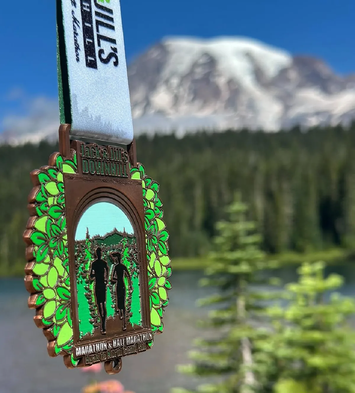 jack and jill's half marathon medal in front of mountain and forest