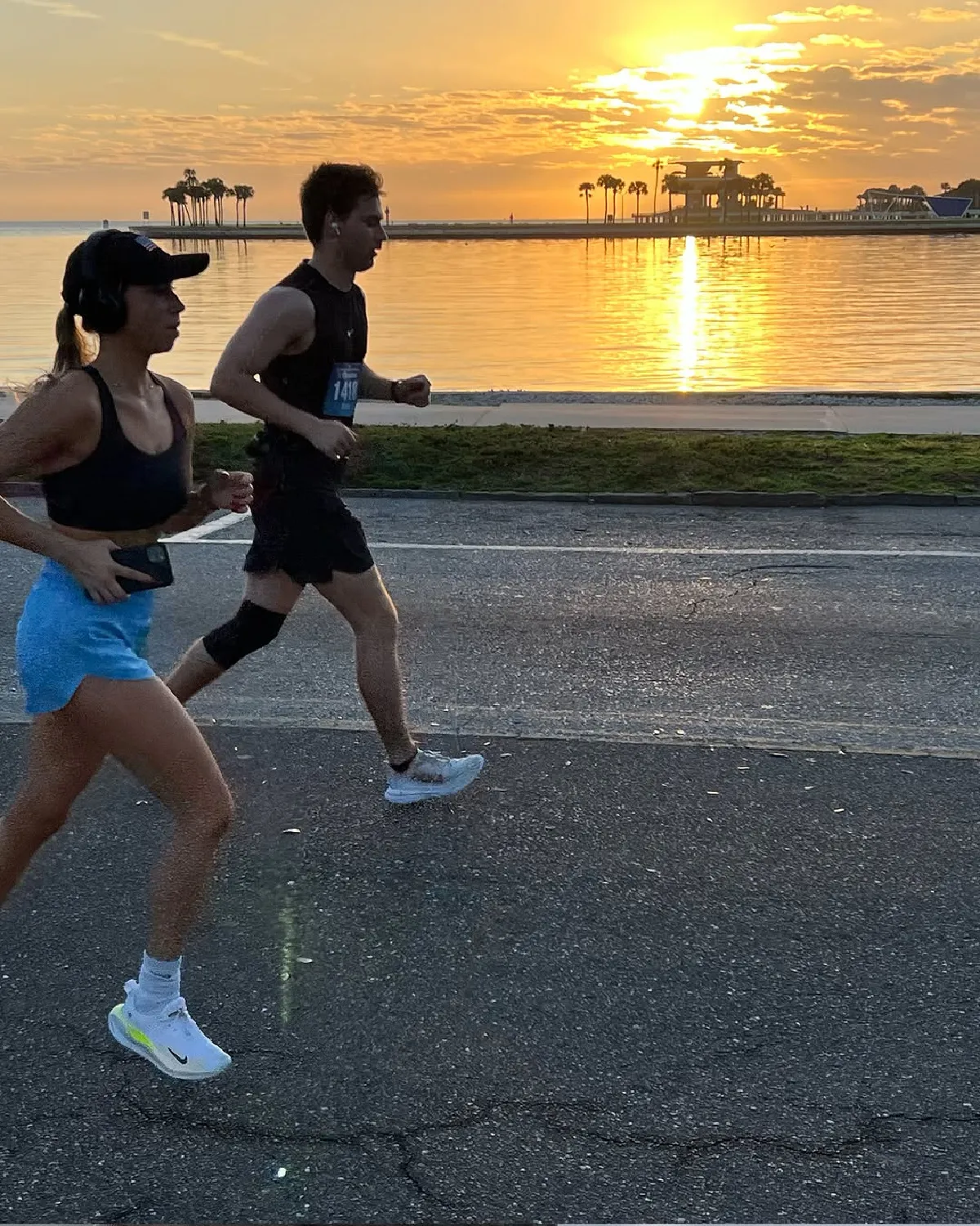 two runners against sunrise over water, St. Petersburg Florida marathon