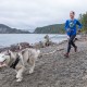 woman and husky running on the deception pass coastline
